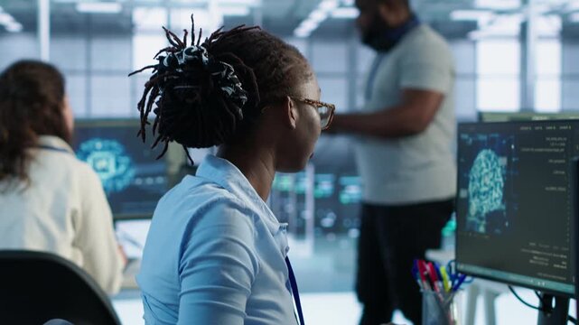 Happy computer scientist programming in AI data center while connecting protected data, access control and server room reliability.