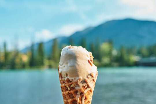 A waffle cone of ice cream melting in the summer heat