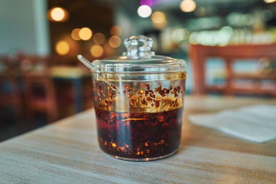 Jar of chili oil glowing under restaurant lights