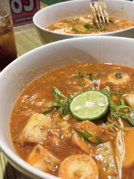 Delicious Indonesian spicy seblak soup with lime slice served in a white bowl