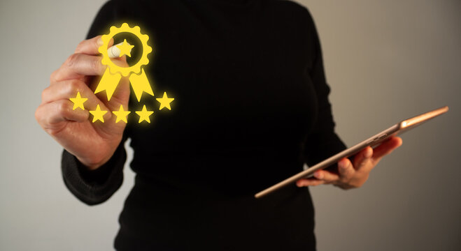 Person displaying a digital award badge with stars and holding a tablet