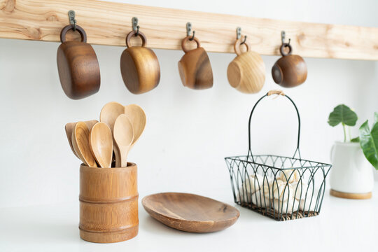 Wooden cup hanging, wooden utensil and garlic in a basket
