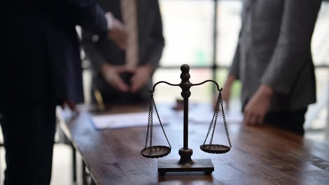 Lawyers shaking hands in a courtroom with scales of justice