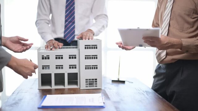 Architects discussing building model and documents