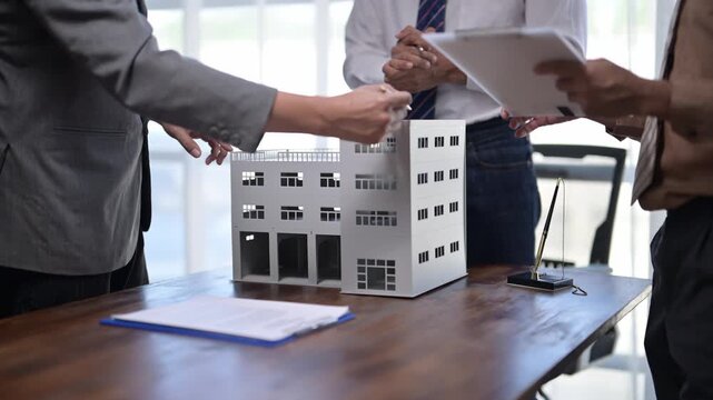 Architects discussing building model and contract