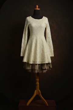 Off-White knitted dress with sheer lace long sleeves with brown skirt displayed on a mannequin