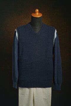 Men's fashion knitwear, navy vest over sweater on display mannequin
