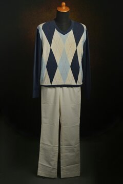 Argyle sweater with white trousers displayed on a mannequin 