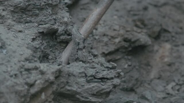Macro detail of an industrial heavy drill bit chiseling and destroying dark stone during excavation.