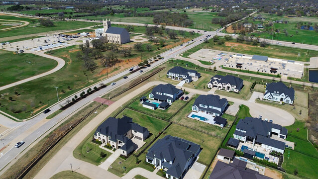 Expansive residential properties parallel primary thoroughfares near Terracina subdivision. Wide perspective shot highlights custom estates, swimming pools, open acreage. Flower Mound, TX