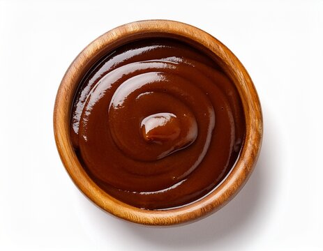 top down view of dark brown sauce in a round wooden bowl