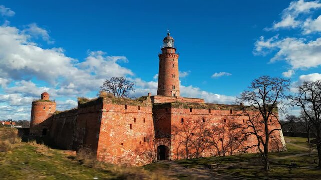Lighthouse on red brick fortress with blue sky