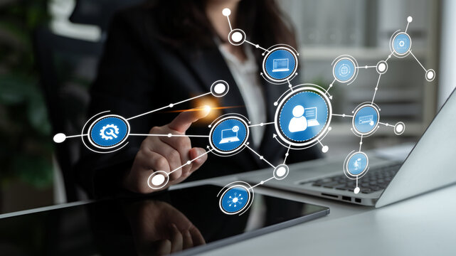 A professional businesswoman engages with a futuristic digital interface, illustrating communication and technology in a modern office environment. Tessel