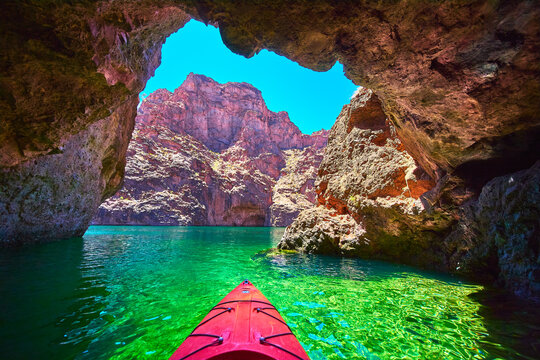 Kayak Enters Emerald Cove Cave On Colorado River With Rocky Canyon And Sunlit Water