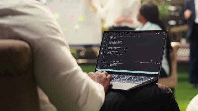 Businessman programmer using binary code on laptop during informal work on outdoor terrace, combining software development with business IT engineering, tech worker, for software development.