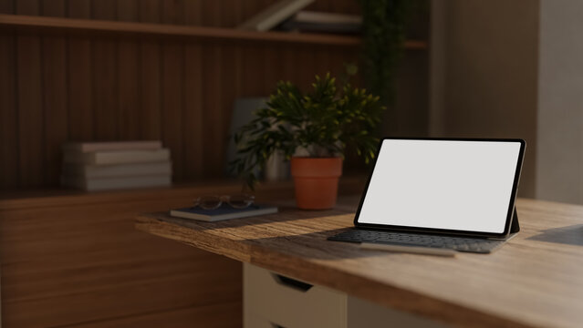 Digital tablet computer mockup with blank screen on wooden office desk
