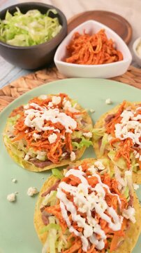 Tostadas de Tinga served on a green plate. Mexican food