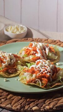 Close-up with direct flash light of Mexican chicken tostadas with shredded chicken tinga and cotija cheese