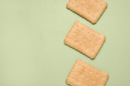 Tasty biscuits on green background, top view