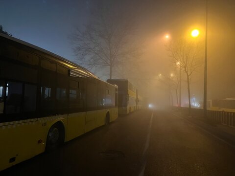 Public buses parking road at foggy night in Istanbul, Turkey.
