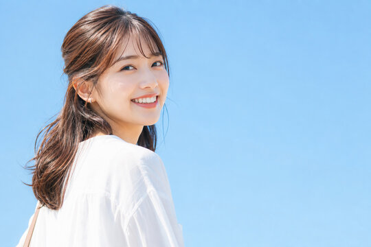 澄み渡る青空と満面の笑みの日本人女性 Generative AI