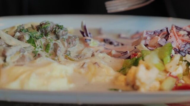 Fork reaches toward a comforting homemade meal with rich sauce
