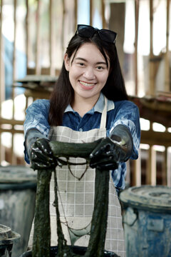 A skilled artisan prepares cotton fibers for traditional indigo dyeing in Sakon Nakhon, Thailand.
