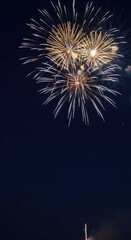 Fototapeta premium Sophisticated holiday celebration backdrop featuring brilliant golden and shimmering silver fireworks exploding across a deep navy blue sky, golden, year-end, bokeh