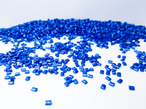 Blue masterbatch granules, cold cutting type, polymer carries color pigment poured into a white background medium, suitable for product catalog design of industrial plastic company profiles