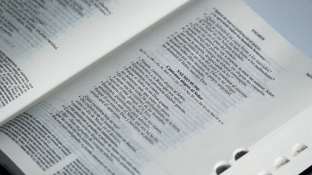Detailed view of a male hand turn pages of a holy bible in spanish