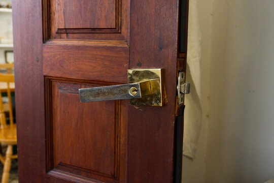 Close-up of wooden door with classic golden handles and ornaments,gold door handle and lock,Beautiful entrance to an expensive home or Luxury hotel,Copy space.