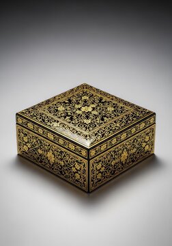 Luxurious black decorative box adorned with intricate gold patterns resting on a smooth neutral gray surface under soft studio lighting, luxury, modern, gray