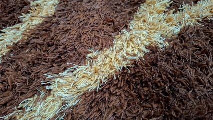 Detailed texture of soft fluffy shaggy rug with diagonal cream and brown lines. Perfect for modern interior design background, 3D surface mapping, and home decor visual © Bendy Moe