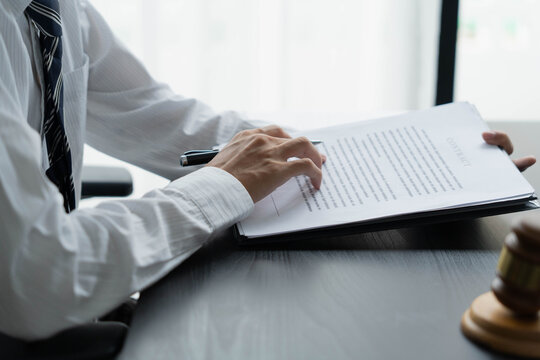 Lawyer reading legal document in office room