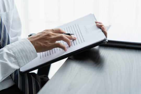 Lawyer reading legal document in office room
