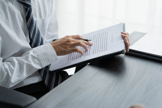 Lawyer reading legal document in office room