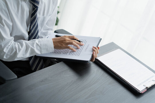 Lawyer reading legal document in office room