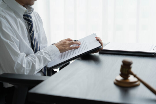 Lawyer reading legal document in office room