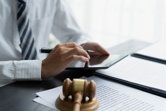 Lawyer using tablet checking legal document in office room