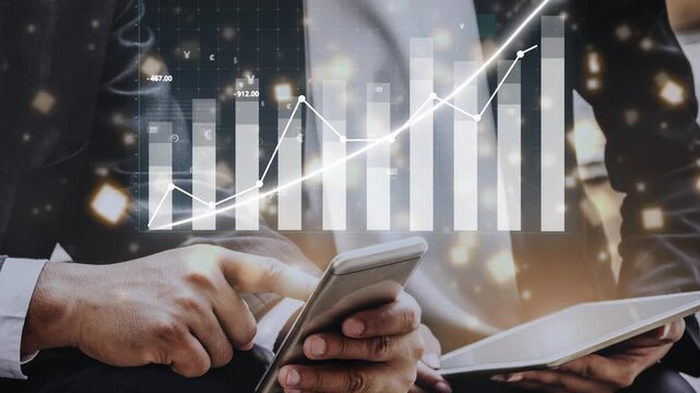 A businessman uses his smartphone to analyze financial trends and growth data, showcasing modern technology and professional success in a contemporary office setting. Copula