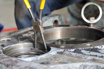 Fototapeta premium Mechanic Using Retaining Ring Pliers on Machinery.
