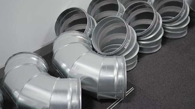 Stacks of galvanized steel duct elbows and connectors awaiting HVAC installation