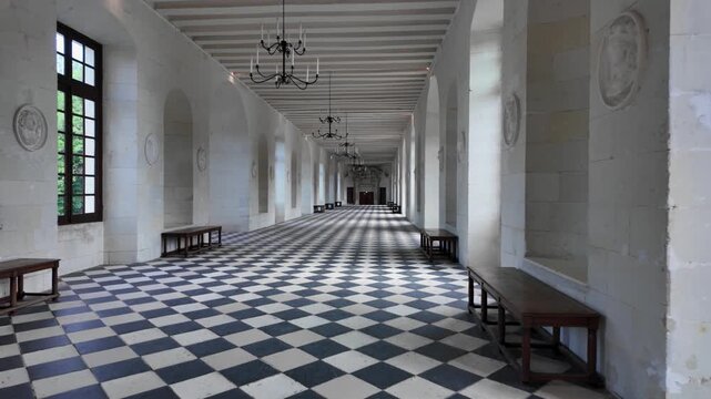 Slow motion video showcasing the iconic Grand Gallery inside Chateau de Chenonceau, featuring the famous black and white checkered floor, elegant arches, chandeliers, and Renaissance architecture
