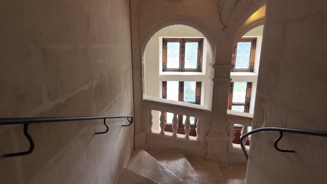 Slow motion video of the elegant stone staircase inside Chateau de Chenonceau, showcasing Renaissance architecture, vaulted ceilings, arched windows, and historic interior details in the Loire Valley