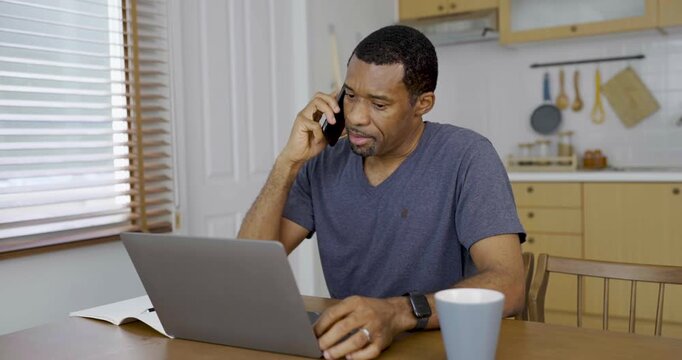 Happy African american business afro man wearing glasses talking with phone during online video meeting at home, showing remote Freelance communication virtual connection.