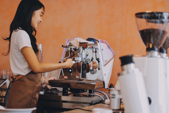 Young woman at barista school learning how to make espresso coffee.