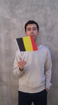 Vertical shot of a person waving Belgian flag in slow motion. Belgium country flag.