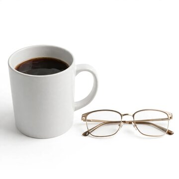 Clean white coffee mug with dark coffee and modern reading glasses on a bright white background, illuminated by soft studio light, creating a minimalist and focused work or study scene.