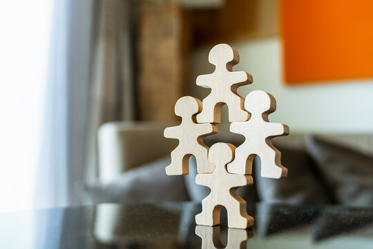 Wooden figure character holding up organization structure on one shoulder, burden of responsibility, lone key leader in business corporate concept.