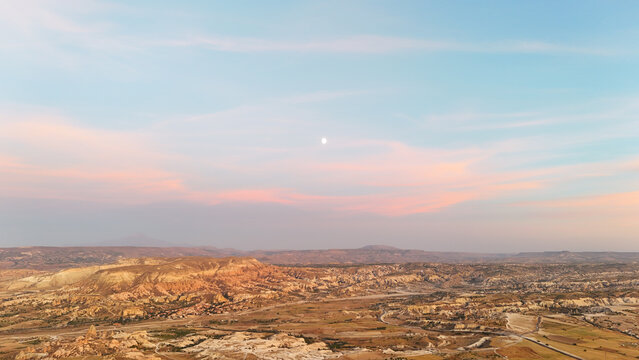 Aerial View of Cappadocia's Fairy Chimneys Under a Twilight Sky with a Visible Moon